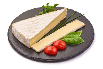 Fresh Brie cheese on a slate shale plate, French Camembert cheese, close-up, isolated on white background