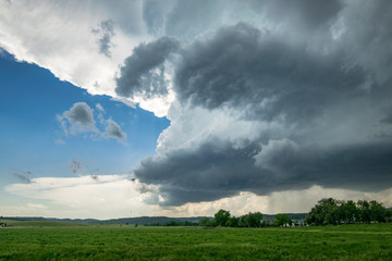 Classic supercell thunderstorm with rotating wallcloud and anvil over 