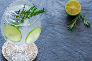 Gin and tonic cocktail with lime and rosemary - refreshing summer alkoholic drink