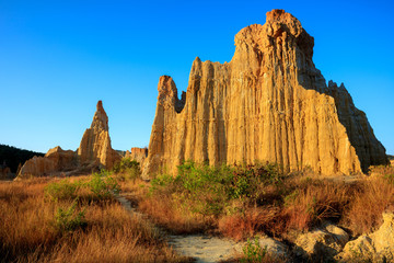 Earth Forest of Yuanmou in Yunnan Province, China - Exotic earth and sandstone formations glowing in the sunlight. Naturally formed pillars of rock and clay with unique erosion patterns. China Travel