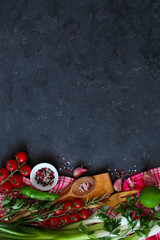 Wooden spoon and knife with ingredients on dark background. Top view with copy space. Cooking concept.