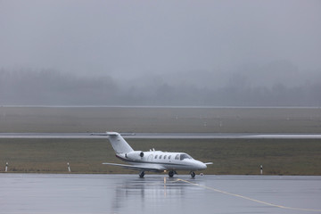a private jet on an rainy airport