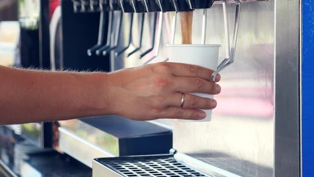 Man pouring beverage from dispenser, closeup