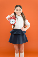 Schoolgirl child formal uniform hold alarm clock. Time to study. Classes begin. Developing...