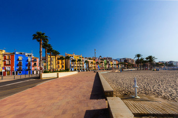 Street embankment with colorful houses and palm trees on a sunny day,Villajoyosa, Costa Blanca, Spain