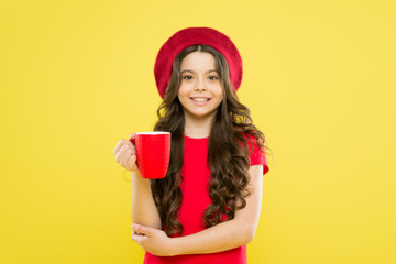 little girl in french style hat. Tea time. beauty and fashion. childhood. hairdresser salon. parisian child on yellow backdrop. happy girl with long curly hair in beret. girl teenager in french beret