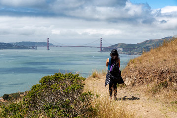 Hiker on trail to Mt. Livermore on Angel Island in San Francisco Bay with Golden Gate Bridge in background