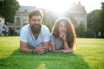 Adding some romance. Holiday romance of bearded man and sexy woman. Couple in love relaxing on green grass on sunny summer outdoor. Feeling romance. Love and romance