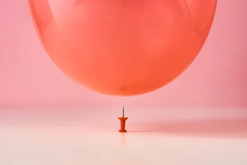Gardinen  Red balloon fall on a pin needle on pink background. Danger or protection concept © Lazy_Bear
