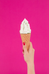 Female hand holding ice cream in waffle cone