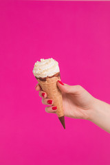 Female hand holding ice cream in waffle cone