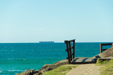 Fototapeta na wymiar Vista para o mar com um grande navio no horizonte.