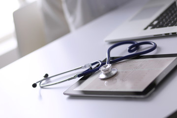 Medical equipment: blue stethoscope and tablet on white background. Medical equipment