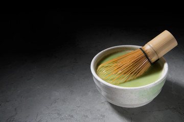 Green matcha tea drink and tea accessories on grey marble background. Japanese tea ceremony concept. Copy space