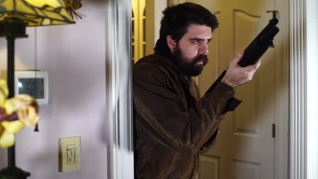 man with shotgun patrolling house