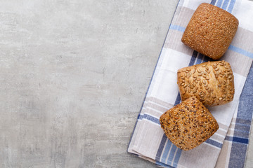 Gold rustic crusty loaves of bread and buns on wooden background. Still life captured from above top view, flat lay.
