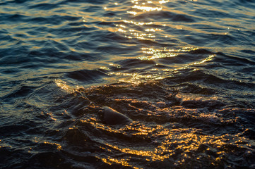 pebble stones on the sea beach, the rolling waves of the sea with foam
