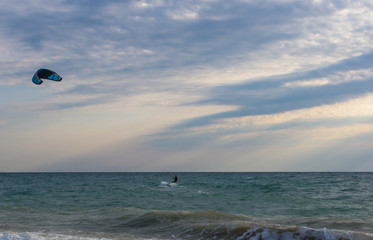 kitesurfer rides a kite-surf on waves of the sea