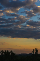 Landscape with dramatic light - beautiful golden sunset with saturated sky and clouds.