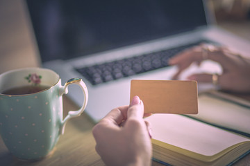 Young woman holding credit card and using laptop computer. Online shopping concept