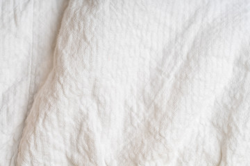 Naklejka na ściany i meble Crumpled white fabric with a large texture.