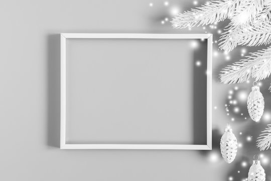 Christmas modern composition. Blank frame for text, white Xmas decorations on gray background. Christmas, New Year, winter concept. Flat lay, top view, copy space