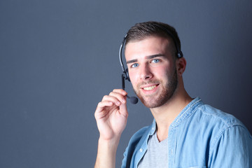 Portrait of young male with microphone. Call-center assistant. Help desk worker.