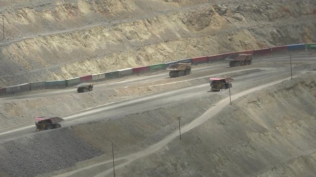 Giant trucks crawling in copper mine