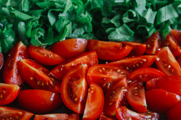 Chopped tomatoes and bright green spinach on wooden rustic table
