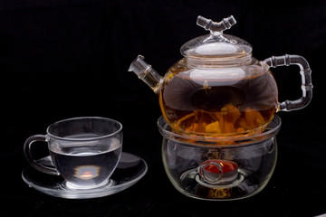 glass teapot and mug on black background