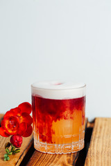 glass with cocktail and red flower