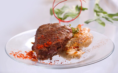 Grilled Chicken breast and Pork chop with beef meat steak and herbs in transparent plate.