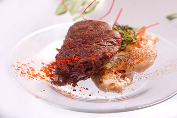 Grilled Chicken breast and Pork chop with beef meat steak and herbs in transparent plate.