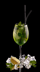 alcohol cocktail on a black background with fresh summer fruits and ice cubes - 276017602