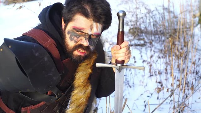viking man in snow with sword