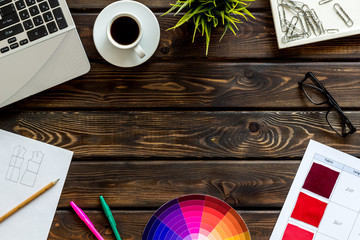 Work space of designer with instruments, pallet, laptop, glasses and coffee wooden background top view space for text