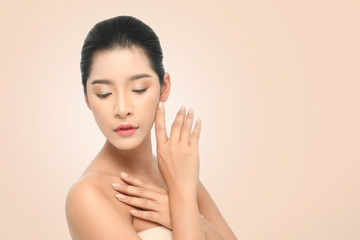 Beautiful Young Woman with clean fresh skin, Proposing a product. Gestures for advertisement on beige background