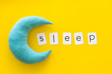Night sleep concept with moon on yellow background top view