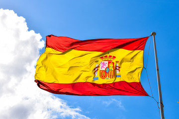 Spanish Flag blowing in a wind on a clouded sky background