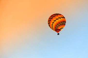 Hot air colourful baloon over blue sky.  Traveling by balloon at sunset.