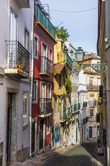 Fototapeta na wymiar Lisbon, Portugal - May 18, 2019: Street perspective view with colorful traditional houses