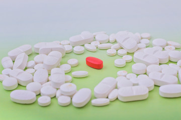 white medicine pill on green background and red in center