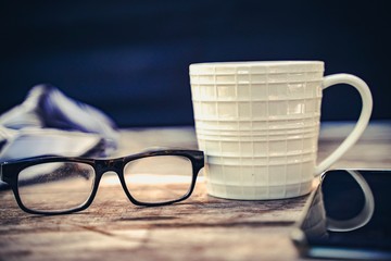 cup of coffee and glasses on table. Father's day empty space background.Office morning coffee.Business concept