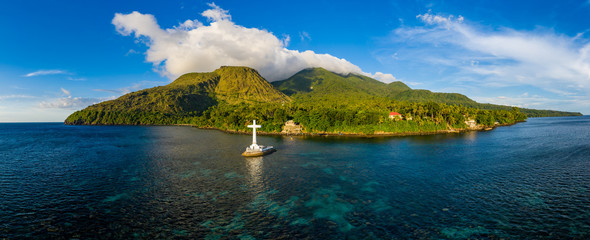 Aerial panorama of the Sunken Cemetery and background volcanos in the evening light on Camiguin...
