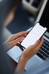 High angle closeup of unrecognizable businesswoman holding smartphone with blank screen, copy space