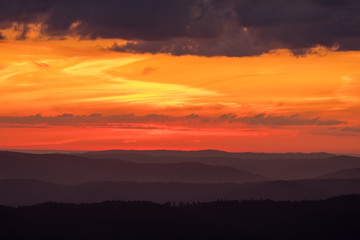 Orange sky, clouds and mountains. Beautiful sunrise in the Bieszczady mountains. Poland