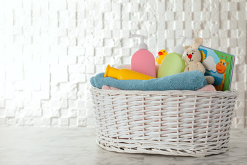 Basket with different baby accessories on table. Space for text
