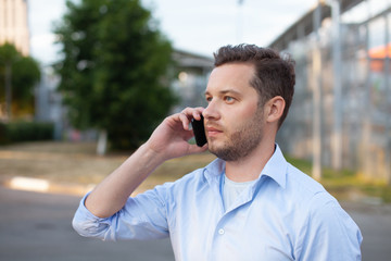 Portrait of sales representative. Logistics manager calling to his business partner to have a deal. Concept of warehouse outdoor and transportation services. .