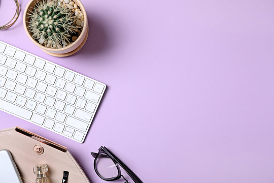 Flat lay composition with keyboard, cactus and fashion blogger's stuff on lilac background. Space for text