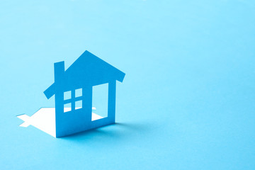 Concept of house in paper on blue color background for real estate property industry - obrazy, fototapety, plakaty
